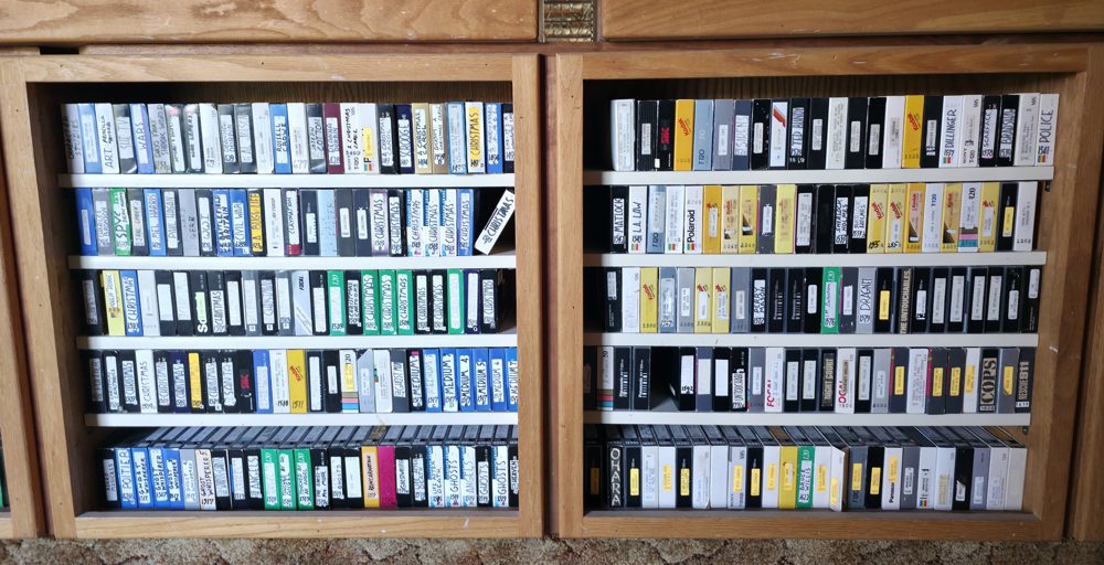 Close-up of a shelf of labelled VHS tapes